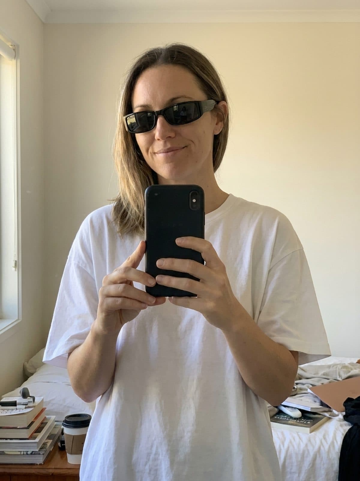 Kobieta w czarnych prostokątnych okularach Goya Poniente — selfie w lustrze